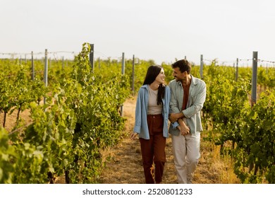 Young couple shares a joyful moment among verdant vines, laughing and embracing under the warm sun, celebrating love and the serenity of a picturesque vineyard - Powered by Shutterstock