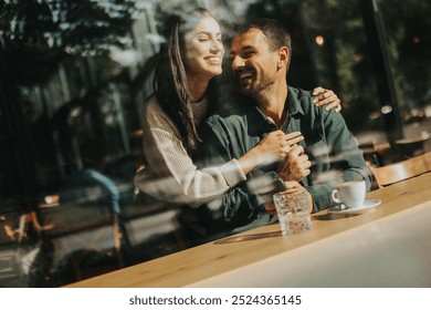 Young couple shares tender moments at a café, surrounded by greenery and natural light, as they connect over warm drinks and playful gestures - Powered by Shutterstock