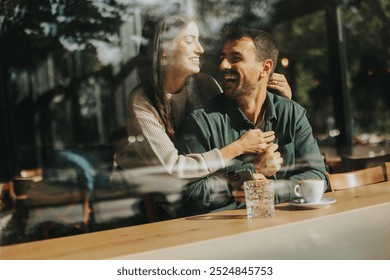 Young couple shares tender moments at a café, surrounded by greenery and natural light, as they connect over warm drinks and playful gestures - Powered by Shutterstock