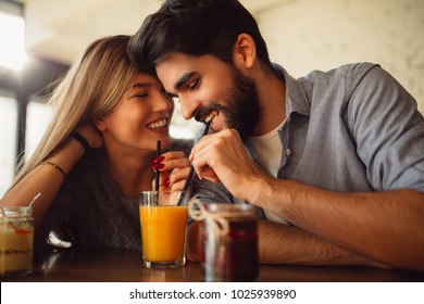 Young couple sharing drink in cafeteria. - Powered by Shutterstock