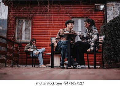 Young couple sharing a moment with hot beverages on a rustic cabin's front porch, exuding warmth and happiness. - Powered by Shutterstock