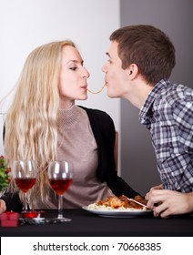 Young Couple Sharing A Spaghetti On Romantic Diner