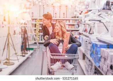 Young Couple Shopping For DIY Tools At Hardware Store.cheerful Young Couple Shopping In Hardware Store