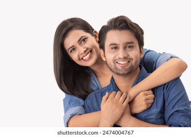 A young couple showing affection with their arms wrapped around the man's shoulder.