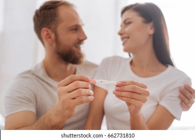 Young couple showing pregnancy test together