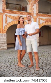 Young Couple Site Seeing On A Hot Summer Afternoon On A Paved Street