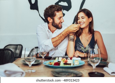 young couple sitting in a cafe and feed each other the juicy cakes - Powered by Shutterstock