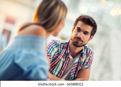 Young couple sitting in a cafe, talking and enjoying on the first date