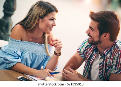 Young couple sitting in a cafe talking and enjoying on the first date