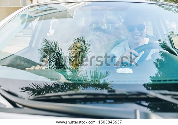 Young couple sitting in the car\
behind the windshield and travelling together in the\
city