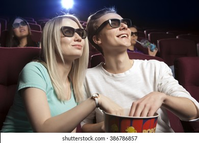 Young couple sitting at the cinema, watching a film. Cinema photo series