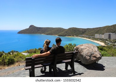 Young Couple Sitting Looking Out Over Passage Peak On Hamilton Island