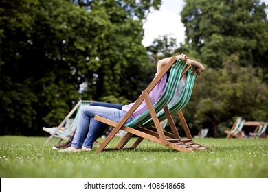 A Young Couple Sitting On Deckchairs In St James Park