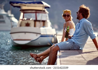 A young couple is sitting on the dock on the seaside and chatting on a beautiful sunny day. Love, relationship, holiday, sea - Powered by Shutterstock