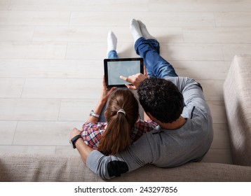 Young couple sitting on floor and using tablet.Relaxing.View from above.