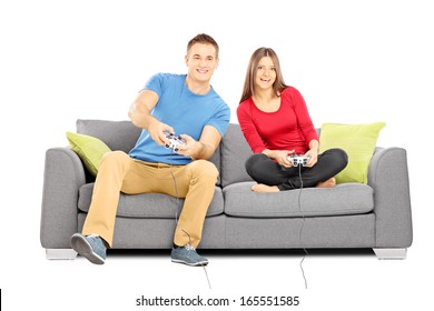 Young Couple Sitting On A Modern Couch And Playing Video Games Isolated On White Background