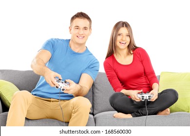 Young Couple Sitting On A Modern Sofa And Playing Video Game Isolated On White Background