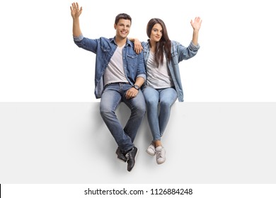 Young Couple Sitting On A Panel And Waving At The Camera Isolated On White Background