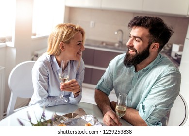 Young couple sitting at the table and drink wine.