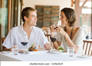 A young couple sitting at a table at an outdoor restaurant