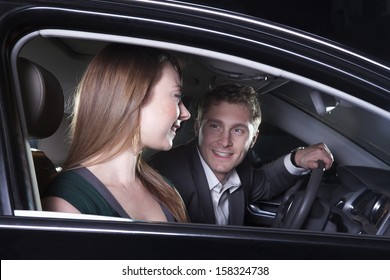 Young Couple Sitting In Their Car And Arriving At A Red Carpet Event At Night In Beijing