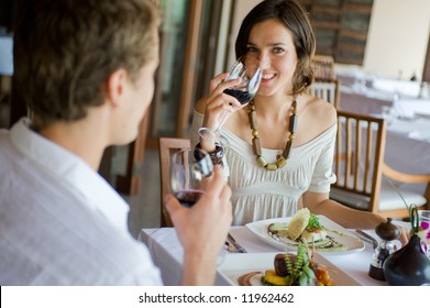 A young couple sitting together in a sophisticated restaurant - Powered by Shutterstock