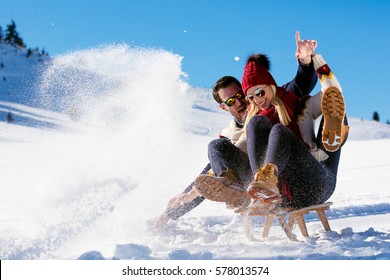 Young Couple Sledding And Enjoying On Sunny Winter Day - Powered by Shutterstock