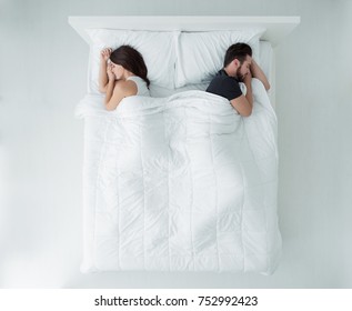 Young Couple Sleeping In Bed Back To Back, Top View