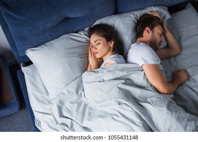 Young couple sleeping in bed in modern bedroom
