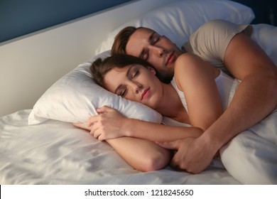 Young Couple Sleeping In Bed At Night