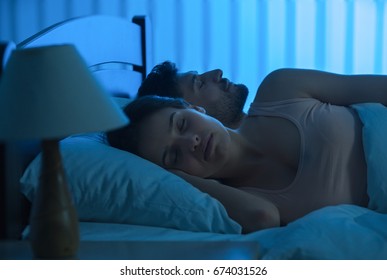 The young couple sleeping in the bed. night time, full grip focus