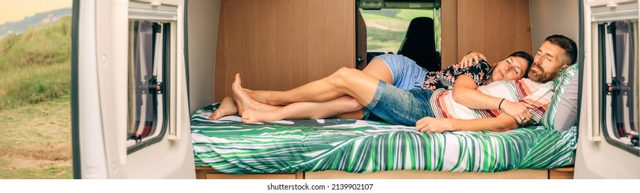 Young couple sleeping embraced in the bed of their camper van with legs intertwined - Powered by Shutterstock