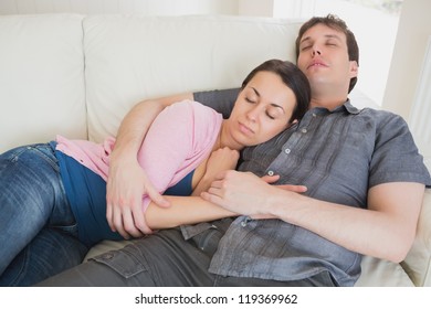 Young Couple Sleeping On The Couch In The Living Room