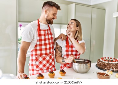 Young Couple Smiling Confident Cooking Chocolate Cake At Kitchen