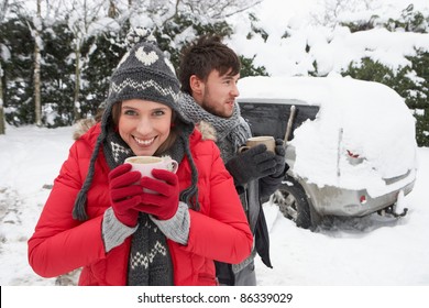Young Couple In Snow With Car