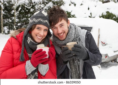 Young Couple In Snow With Car