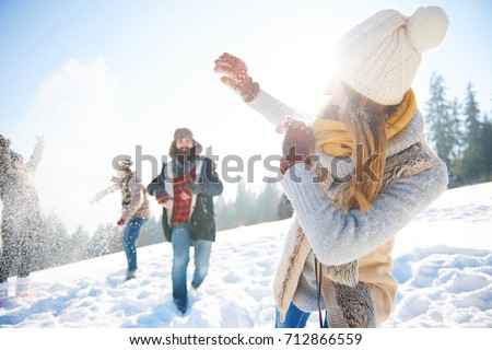 Young couple in snowball fight 