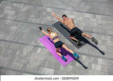 Young Couple In Sports Outfit Doing Morning Workout Outdoors. Man And Woman Doing Cardio And Strenght Exercises, Practicing Activity For Lower And Upper Body. Sport, Healthy Lifestyle Concept.