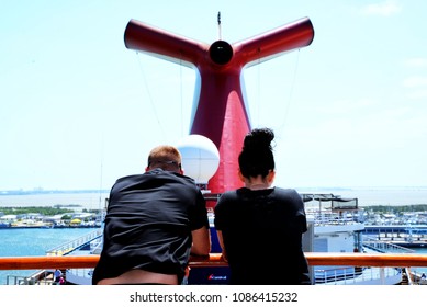 Young Couple Is Standing In Front Of The Carnival Liberty Funnel. Carnival Cruise Lines. 28 February 2018. Port Canaveral,  Florida State