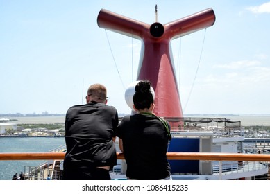 Young Couple Is Standing In Front Of The Carnival Liberty Funnel. Carnival Cruise Lines. 28 February 2018. Port Canaveral,  Florida State