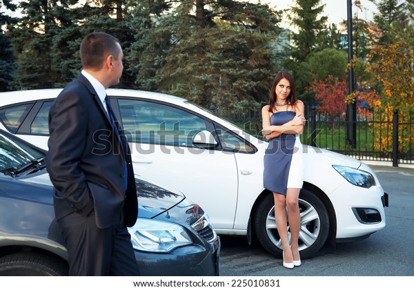 young\
couple standing near the car. choice car\
dealership