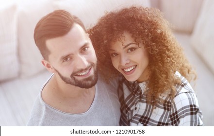 Young Couple Standing In New Living Room And Looking At Camera