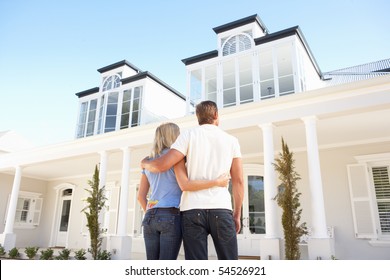 Young Couple Standing Outside Dream Home