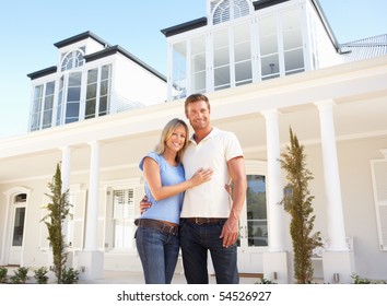 Young Couple Standing Outside Dream Home