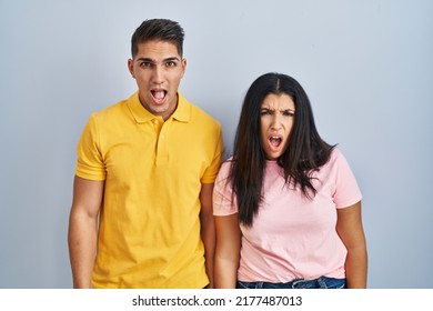 Young Couple Standing Over Isolated Background In Shock Face, Looking Skeptical And Sarcastic, Surprised With Open Mouth 