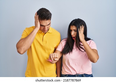 Young Couple Standing Over Isolated Background Looking At The Watch Time Worried, Afraid Of Getting Late 