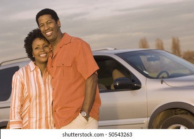 Young couple standing together in front of car, half-length