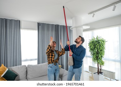 Young couple stares at the ceiling and yells because a neighbor upstairs is having a party with loud music or renovating an apartment and workers are drilling with heavy tools - Shutterstock ID 1965701461