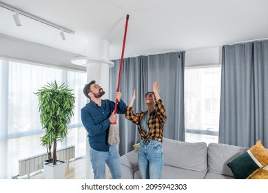 Young couple stares at the ceiling and yells because a neighbor upstairs is having a party with loud music or renovating an apartment and workers are drilling with heavy tools. Nise pollution concept
