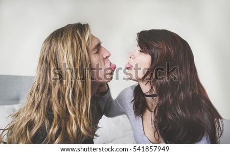 Young couple sticking their tongues out at each other in a playful way